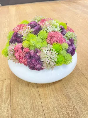 colorful flowers in small white pot.